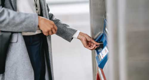 Person taking money from an ATM machine.
